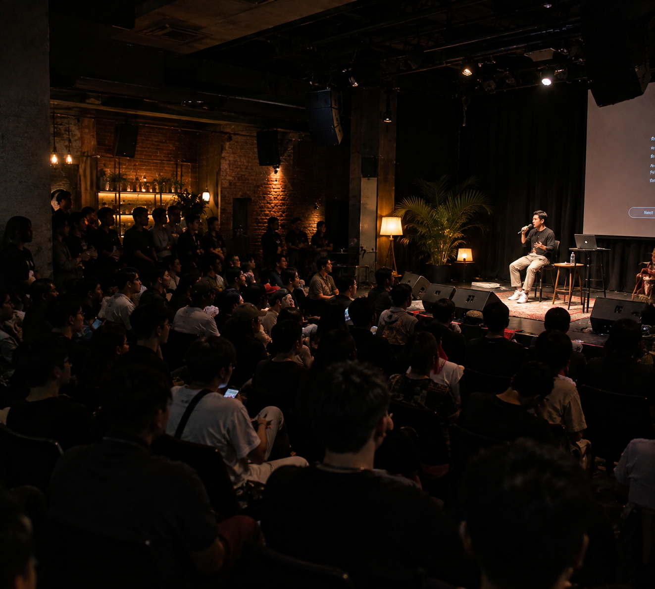 Audience gathered for a talk in a loft venue
