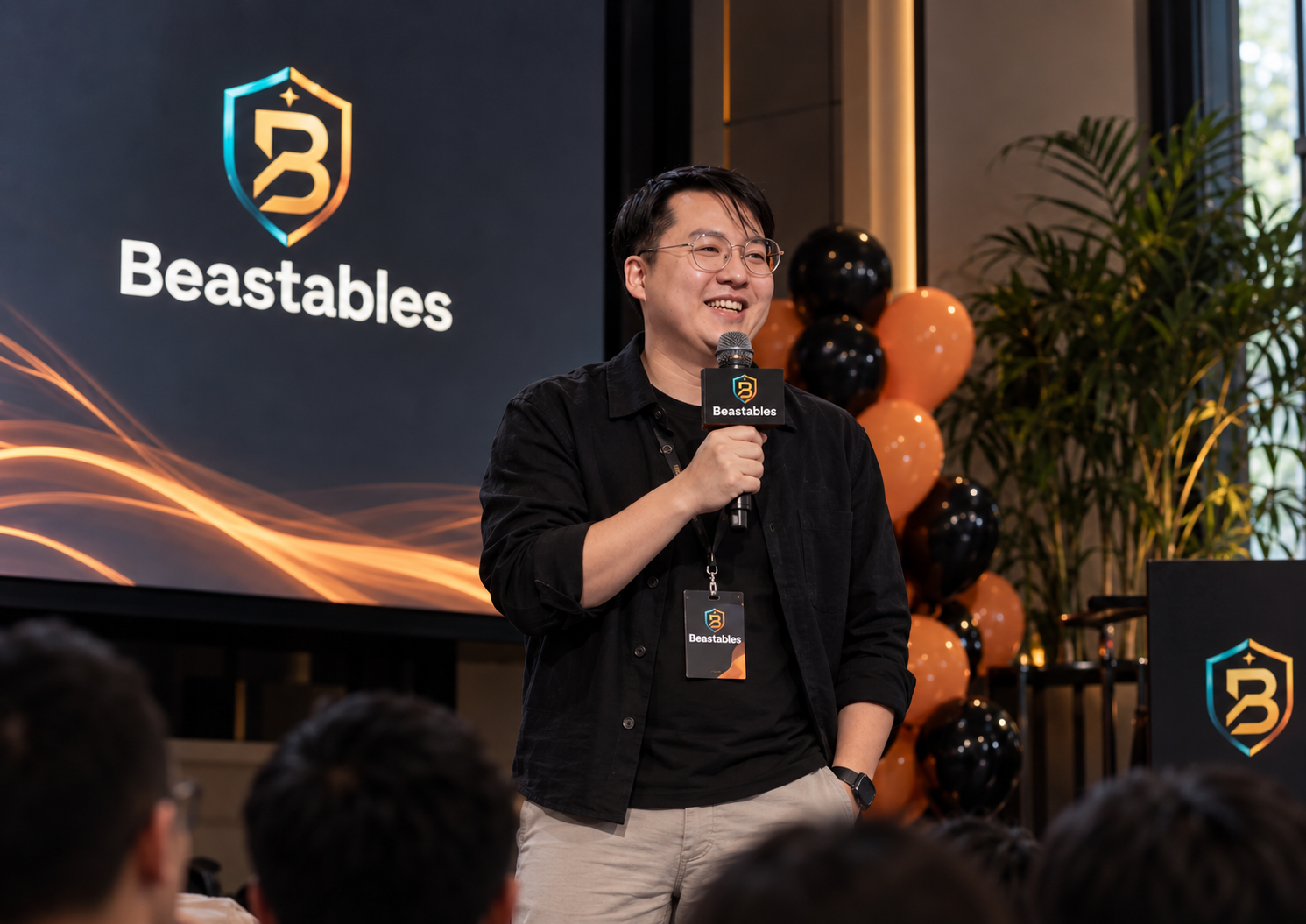 Speaker holding a microphone beside Beastables branding